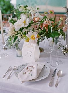 the table is set with flowers and silverware