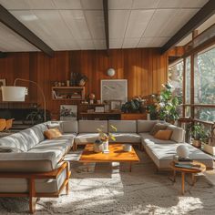 a living room filled with lots of furniture and wooden paneling on the wall behind it