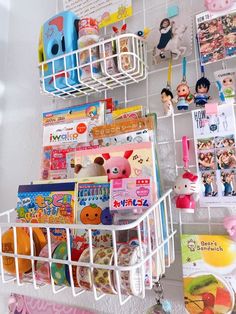 a white shelf filled with books and toys next to a wall covered in magnets