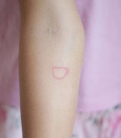 a woman's arm with a small tattoo on the left side of her arm