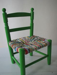 a green chair with a multicolored seat cushion