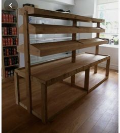 a wooden bench sitting in the middle of a room with bookshelves on each side