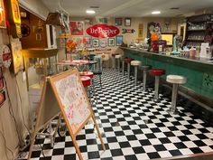 a checkered floor in a restaurant with tables and stools next to the counter