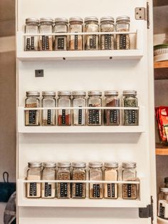 the spice rack is full of spices and seasonings in glass jars on white shelving