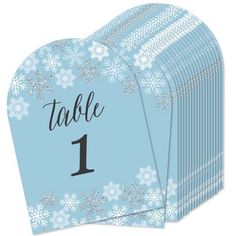 a blue table number card with snowflakes on the front and one in the middle