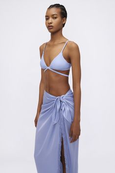 The Clemmy Sarong in Marina Blue. This piece elevates beachwear with its lustrous fabric and fringe detailing. Its wrap-around style offers both coverage and a glamorous flair for poolside lounging or strolls along the shore. Summer Swimwear With Wrap-around Straps For Vacation, Summer Poolside Wrap Swimwear, Beachwear Wrap Swimwear For Poolside, Blue Wrap Sarong For The Beach, Blue Wrap Sarong For Beach, Beachy Wrap Swimwear For Poolside, Wrap Swimwear For Beach Season And Poolside, Summer Pool Swimwear With Wrap-around Straps, Wrap Swimwear For Poolside And Beach Season