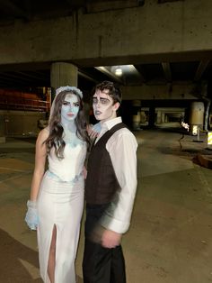 a man and woman dressed up as corpse brides pose for a photo in an empty parking garage