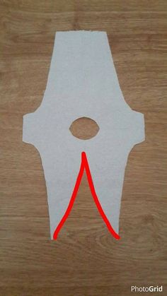 a piece of paper that has been cut out to look like a mask with an arrow on it