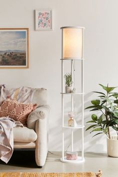 a living room filled with furniture and a white shelf next to a potted plant