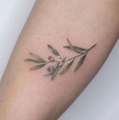 a close up of a person's arm with a flower tattoo on the side