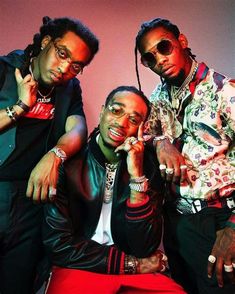 three young men posing for the camera in front of a pink wall with sunglasses on