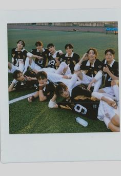 a group of young people sitting on top of a soccer field