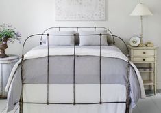 a bedroom with white walls and flooring has a metal bed frame