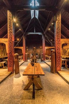 a wooden bench sitting in the middle of a room filled with statues and other items