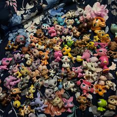 a pile of littlest pet toys sitting on top of a blue cloth covered floor