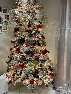 a white christmas tree with red and gold ornaments