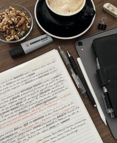 a notepad, pen, cup of coffee and other items on a table