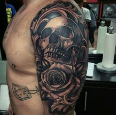 a man with a skull and rose tattoo on his arm