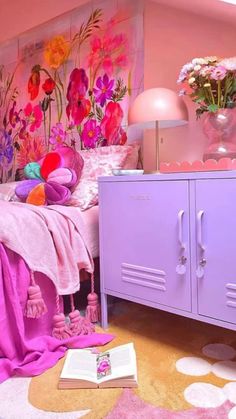 a bedroom with pink walls and flowers on the headboard is decorated in bright colors