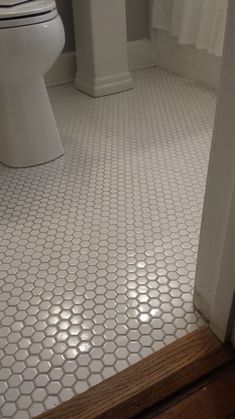 a white toilet sitting in a bathroom next to a doorway