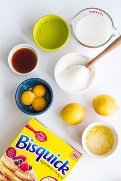 ingredients to make pancakes laid out on a white counter top, including eggs, yogurt, sugar and lemons