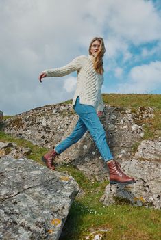 a woman standing on top of a rock formation