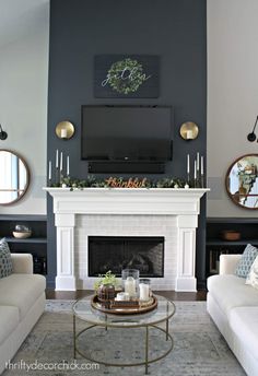 a living room with two couches and a tv above the fireplace in front of it