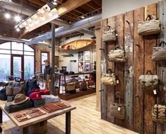 a room filled with lots of bags hanging from the ceiling and wooden walls next to windows