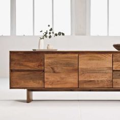 the sideboard is made out of wood and has two bowls on top of it