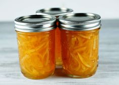 two mason jars filled with pickles sitting on top of a table