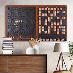 a wall mounted board game sitting on top of a wooden dresser next to a lamp