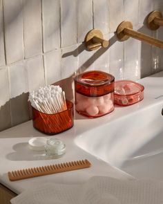 toothbrushes and other items are sitting on the sink