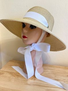 This 4 inch down turn brim Toyo straw hat is very durable and keeps the shape, great for travel. The hat has a removable white Grosgrain ribbon band and under chin tie. The hat will fit up to 22 7/8 inch head size with an inside sizing cord to adjust to your head size. You can easily remove the tie and use another ribbon or scarf to match your outfit. There are several ribbon options available, please see last photo for ribbon chart and put in the notes at check out if you would like a different Cream Straw Hat Bands For Vacation, Cream Straw Hat Band For Vacation, Cream Hat Bands For Summer Vacation, White Straw Hat Bands For Beach, White Toquilla Straw Hat Band For Beach, White Summer Hat Band For Beach, Summer Cream Hat Band For Vacation, Classic Cream Straw Hat For Beach, Summer Vacation Cream Hat Band