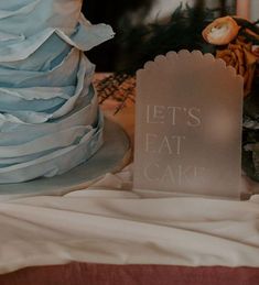 there is a cake on the table next to a sign that says let's eat cake