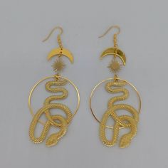 ♡ Cosmic Snake Hoops Dangle Earrings ♡ ♡ Our gold celestial slithering serpent earrings make perfect gifts to delight yourself or those you love! The large snake and hoops at center surrounded by the sun and stars evoke feelings of peace and eternal beauty, especially when kissed by the light. A gorgeous ear hook pair of earrings that shines through and accentuates the beauty of every outfit. Handmade with quality brass stainless steel alloy ♡ C O S M I C ∙ S N A K E ∙ E A R R I N G S ▂▂▂▂▂▂▂▂▂▂ Cosmic Snake, Serpent Earrings, Large Snake, Ouroboros Snake, Largest Snake, Eternal Beauty, Sun Moon Stars, Professional Jewelry, Sun And Stars