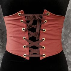 "This waist cincher is made in 100% Cotton in BURNT ORANGE. The perfect compliment to your Witch, Pirate, Renaissance, Medieval or other fantasy cosplay costume. It is lined with cotton duck and it has spring steel boning in the front for stability and to reinforce the grommets (this boning has some flex to it so it will move with you some as well). A very comfortable, yet sturdy piece.   Measure your waist as the smallest point (typically just about the belly button) and choose from the following sizes:  X-SMALL: Waist 25.5 - 28 inches (64 - 71 cm) SMALL: Waist 28 - 31 inches (71 - 79 cm)  MEDIUM: Waist: 30 - 33 inches (76 - 84 cm) LARGE: Waist: 32 - 35 inches (81 - 89 cm) X-LARGE: Waist: 34 - 37 inches (86.5 - 94 cm)  XXLARGE: Waist 36 - 39 inches (91.5 - 99 cm) ✿✿THIS PIECE IS MADE TO O Gothic Brown Corset For Festival, Steampunk Underbust Corset Belt For Costume, Fantasy Corset Belt For Cosplay With Corset Back, Fantasy Corset Belt With Corset Back For Cosplay, Punk Corset For Halloween Larp, Steampunk Corset Belt For Cosplay, Gothic Corset Belt For Festivals, Fitted Medieval Corset Belt For Halloween, Fantasy Corset Belt For Cosplay