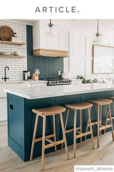 a kitchen island with three stools in front of it and an oven on the other side