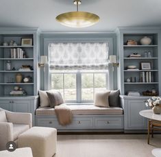 a living room filled with lots of furniture and bookshelves next to a window