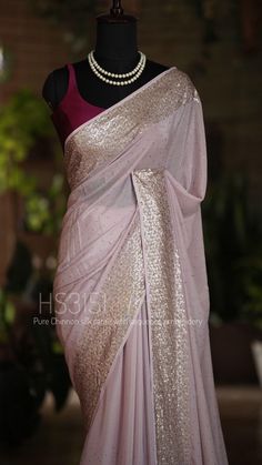 *HS3151 Moonlit Mirage: "Aurora" Collection* "Get lost in the ethereal glow of 'Aurora', a chinnon silk saree that shimmers like a moonbeam. Sequins and knotwork embroidery weave a spell of enchantment on the border, while Swarovski sparkles scatter stardust across the light mauve hue. The heavily embroidered blouse is a masterpiece of midnight sky. This body-hugging, whisper-light saree is a gentle breeze on a summer night, draping you in an aura of soft, luminous beauty." Elegant Chinon Blouse With Gota Work, Elegant Georgette Saree With Gota Work, Party Wear Pre-draped Georgette Saree With Gota Work, Wedding Chanderi Saree With Sequins, Elegant Saree With Mirror Work For Celebration, Festive Party Wear Saree With Gota Work, Elegant Saree With Gota Work In Chinon, Designer Party Wear Saree With Gota Work, Party Wear Saree With Gota Work