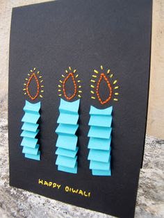 a black card with three pieces of paper cut out of it and the words happy diwali