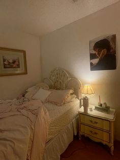 a bedroom with a bed, nightstand and pictures on the wall