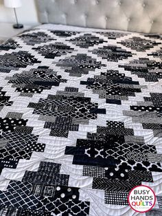 a black and white quilt on top of a bed