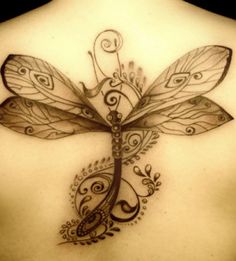 a woman's back with a dragon tattoo on it