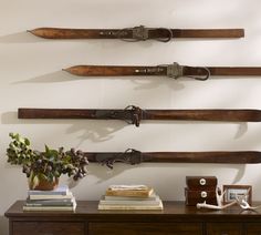 three wooden skis mounted to the side of a wall next to a vase with flowers