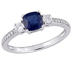 a blue sapphire and diamond ring with three diamonds on the band, set in white gold