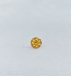 a gold ring sitting on top of a white surface