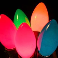 an assortment of colored eggs sitting on top of each other in front of a black background