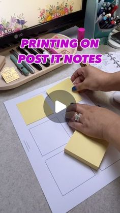 a person cutting out a piece of paper on top of a sheet of paper with the words printing on post - it notes