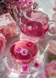 a tea pot with pink flowers in it next to a box and some other items