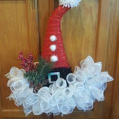 a red and white christmas wreath on the front door